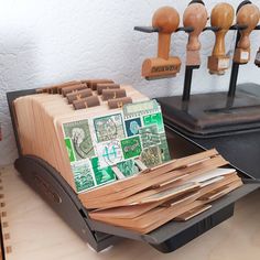 a bunch of stamps sitting on top of a wooden desk next to a stamp dispenser