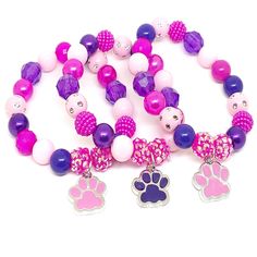 These adorable bracelets are the perfect favor for your little one's paw themed party! Each bracelet features a pink or purple enameled paw charm, resin rhinestone beads and an assortment of pink, purple and hot pink 10mm acrylic beads strung with durable stretch floss cord. Each bracelet comes individually packaged in organza bags. Please message me if you have any questions or if you would like to make some changes to this item. To be the first to know about new items, sales and giveaways, mar Nickel-free Pink Bracelets For Friendship, Playful Pink Charm Bracelet For Birthday, Adjustable Purple Charm Bracelet For Birthday, Pink Round Beads Bracelets For Birthday, Hypoallergenic Pink Charm Bracelet For Friendship, Pink Bracelet For Party Favors, Playful Pink Nickel-free Bracelets, Cute Purple Beaded Bracelets For Birthday, Pink Bracelets With Round Beads For Party Favors