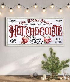 a wooden sign that says hot chocolate bar on it next to a potted plant