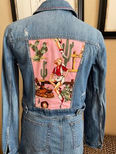 "American Eagle denim distressed jacket Size S/P 100% cotton Chest 34\" Shoulder 13\" Sleeve 25\" Length 18\"  This Cowgirl fabric is adorable and really accentuates the distressed appearance of this cropped jacket. The rose on the front yoke is hand embroidered as the collar." Trendy Fitted Pink Denim Jacket, Pink Cotton Denim Jacket For Spring, Fitted Pink Denim Jacket For Spring, Distressed Cropped Cotton Denim Jacket, Fitted Denim Jacket With Patches For Spring, Fitted Cotton Outerwear With Frayed Hem, Casual Reworked Denim Jacket, Fitted Pink Denim Jacket With Long Sleeves, Pink Fitted Long Sleeve Denim Jacket