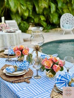 a table set up with flowers and place settings near a swimming pool in the background