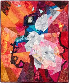 a colorful quilt with many different colors and shapes on it's sides, including an orange