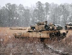 two army tanks in the snow on a snowy day