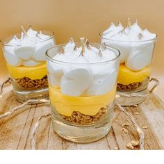 three desserts in small glass dishes on a wooden table