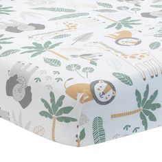 an image of a baby crib sheet with animals and leaves on the coverlet