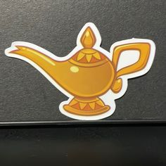 a yellow teapot sticker sitting on top of a laptop