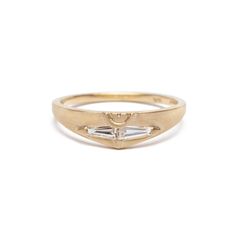 a yellow gold ring with two baguettes on the side and a diamond in the middle