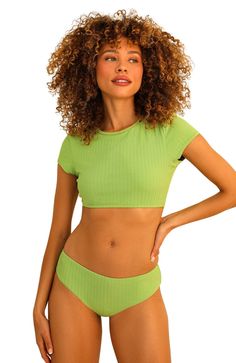 Our Joni Top is the perfect poolside crop! With a flirty bikini fit, you’ll be sure to turn heads wherever you go. Looks great paired with any of your favorite bikini bottoms – it’s the ideal choice for a sizzling vacay under the sun! 87% Nylon 13% Spandex Imported from Vietnam Crew neckline Short cap sleeve Cropped shirt style Green Stretch Crop Top For Beach Season, Fitted Crop Top For Poolside Beach Season, Fitted Crop Top For Sunbathing In Summer, Summer Fitted Crop Top For Poolside, Fitted Crop Top For Pool And Summer, Trendy Cropped Swimwear For Spring, Green Seamless Summer Crop Top, Cropped Swimwear For Beach Season Vacation, Cropped Swimwear For Beach Vacation