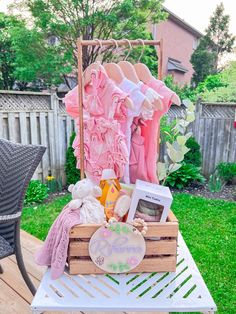 a wooden crate filled with clothes on top of a table next to a patio chair