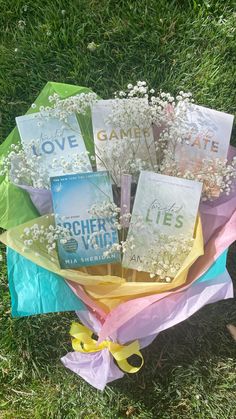 a bouquet of flowers sitting on top of a grass covered field next to some cards