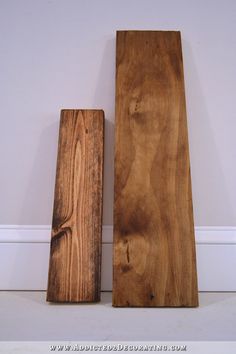 two pieces of wood sitting on the floor next to each other in front of a wall