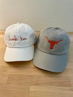 Texas Longhorn fans! These hats are 100% cotton with an adjustable back closure. Choose from "hook 'em" or the longhorn emblem to show your team spirit!  *If no color is chosen, default color will be Burnt Orange thread for the white, grey, and black hats, or White thread for the Burnt Orange Hat Adjustable Baseball Cap For Fan Gear, Adjustable Curved Brim Hats For Game Day, Adjustable Dad Hat With Curved Brim For Sports Fans, White Cotton Hat For Game Day, Adjustable Cotton Fitted Hat For Fan Gear, Adjustable Fitted Hat With Curved Brim For Game Day, Adjustable Curved Brim Fitted Hat For Game Day, Adjustable Cotton Dad Hat For Fan Gear, Adjustable White Hat For Game Day