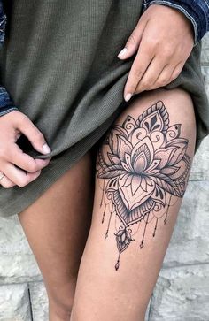 a woman's thigh with a tattoo on it and a flower in the center