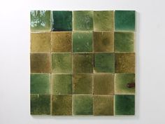 a piece of art that looks like it has been made out of green and brown tiles