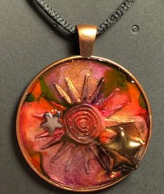 a necklace with an orange and pink design on it