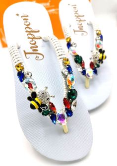 Description The beautiful rhinestone and customizable Flip Flops for the beach brides, bridesmaids, vacation, honeymoon or any occasion you desire to look gorgeous. Perfect in any outfit! Being unique and stunning on design, these flip flops must be your must-have item! The sandal is anti-slip, comfortable and durable as it is made from high quality rubber from the South of Thailand, where is famous for the best rubber tree. Moreover, the crystals are decorated on the sandal with effective adhes Bedazzled Silver Sandals For The Beach, Bling Open Toe Sandals For Beach, Silver Bedazzled Sandals For Beach, Silver Bedazzled Sandals For The Beach, White Beaded Sandals For Wedding, White Beaded Wedding Sandals, Adjustable Embellished Sandals For Beach Season, Beaded Flip Flops For Summer Party, White Rhinestone Sandals For Vacation