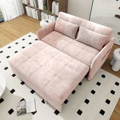 a pink couch sitting on top of a white rug