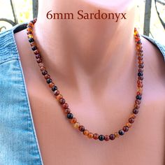 This stunning Sardonyx Bead Necklace is a timeless piece, featuring 6mm round sardonyx beads, celebrated for their captivating dark orange and black patterns. Strung on durable steel wire and finished with a secure steel clasp, this necklace is 20 inches long with a 2-inch chain extender for adjustable wear. A versatile addition to any jewelry collection, it effortlessly transitions from casual to formal attire. Perfect as a birthday gift for women or a thoughtful present for your wife, this sar Sardonyx Stone, Autumn Necklace, Carnelian Necklace, Birthday Gift For Women, Carnelian Stone, Chain Extenders, Dark Orange, Formal Attire, Gift For Wife