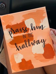 a person holding up a sign that says praise him in the hallway on an orange and white background