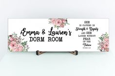 a white sign with pink flowers on it that says, edna & lauren's dorm room