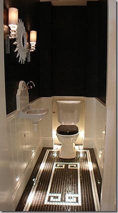 a white toilet sitting inside of a bathroom next to a sink