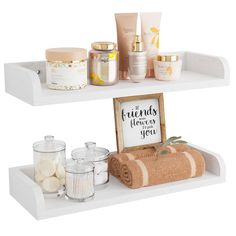 two white shelves with towels, candles and other items