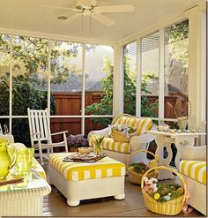 a sun room with yellow and white furniture