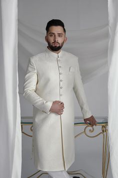 This White Long Sherwani is a stunning choice for your special occasion. Made from printed off-white khaadi silk, it features a silk kurta and cotton pajama for a comfortable fit. Complete your look with the elegant organza Rajastjhani kula (turban) and exude an air of style and sophistication. Elegant Raw Silk Sherwani Straight Kurta, Elegant Sherwani In Raw Silk With Straight Kurta, Elegant Designer Wear Sherwani With Straight Kurta, Silk Kurta For Formal Festivals, Elegant Raw Silk Sherwani With Dabka Detailing, Formal Silk Kurta For Festivals, Elegant Off White Sherwani With Resham Embroidery, Silk Straight Kurta Sherwani For Wedding, Silk Sherwani With Straight Kurta For Wedding