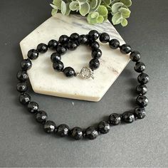 This Stunning Piece Is Hand Knotted And Features Faceted Natural Stones That Catch The Light Beautifully. The Black Onyx Beads Are Sleek And Sophisticated, Making This Necklace Perfect For Dressing Up Any Outfit. Whether You're Heading To A Fancy Event Or Just Want To Add Some Glam To Your Everyday Look, This Necklace Is Sure To Do The Trick. So Why Wait? Treat Yourself To This Gorgeous Piece Today! 10mm Faceted Black Onyx. Stainless Steel Sailor Clasp, Removable Pendant Can Be Added. Black Crystal Necklaces With Round Natural Stones, Black Onyx Crystal Necklace With Black Beads, Black Necklaces With Round Natural Stones, Elegant Black Round Bead Crystal Necklaces, Elegant Adjustable Black Crystal Necklace, Black Onyx Round Bead Crystal Necklaces, Elegant Onyx Crystal Necklaces With Round Beads, Black Gemstone Bead Necklaces, Black Gemstone Beads Necklace