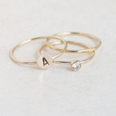 Our personalized gold initial monogram ring, gold diamond (or your choice of gemstone) and a dainty gold stacking ring is the perfect trio of rings. Create your own instant collection of personalized jewelry with this hand selected, artfully curated treasury of gold rings. Be sure to tell us your gemstone / birthstone preference in the note section at checkout!{DETAILS}:* gold filled ring bands (1 mm) & stamping round* 14k solid gold bezel cup * lab created / man made gemstones (conflict free!)* Initial Ring Gold, Monogram Ring Gold, Ring Gold Diamond, Mothers Ring, Pandora Gold, Gold Stacking Ring, Stacked Wedding Rings, Aesthetic Ootd, Diamond Stacking Rings