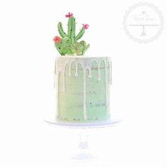 a green cake with white icing and a cactus on top