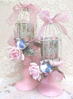 two pink vases with roses and birds in them