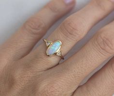 a woman's gold ring with an opal in the center