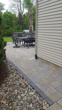 an outdoor patio with table, chairs and umbrella