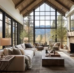 a living room filled with lots of furniture next to large windows and a fire place