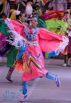 people in colorful costumes are dancing on the street