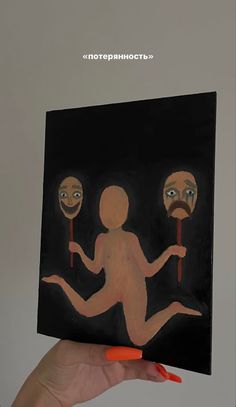 a person holding up a piece of art with three faces on it and one body in the air