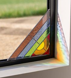 a colorful stained glass window with grass in the background