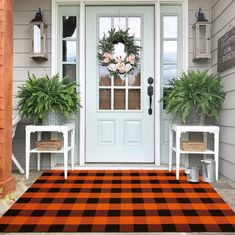 the front door is decorated with plants and wreaths