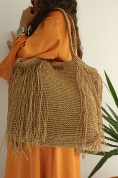 Title: Beach Straw Bag, Tassel Beach Bag, Fringed Straw Bag, Raffia Bag, Resort Style, Woven Bag, Summer Tote, Holiday Bag 🏖️ Our handmade summer bags, meticulously woven, are the perfect choice for beach style and holiday fashion. Made from natural raffia paper thread, these bags will be a favorite for those seeking a bohemian look and unique style. Whether at the beach, on vacation, or for daily use, these bags are both stylish and practical. Follow our page to complement your style and achieve an original appearance. 🚩Features: * Our bags are entirely handmade, meticulously woven and designed with care. * We use 100% natural raffia paper thread, which is of high quality and has a durable structure. * Customizable and tailored specifically to your needs. * Includes an inner pocket to k Holiday Bag, Summer Tote, Bag Summer, Raffia Bag, Bohemian Look, Tassel Bag, Handmade Handbags, Resort Style, Woven Bag