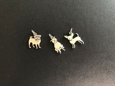 three charms with dogs on them sitting on a table