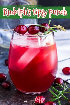 a glass filled with cranberry shrub and garnished with fresh cherries