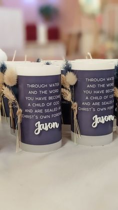 three candles that have been placed on a table with some writing on the candle holders