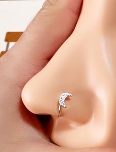 a close up of a person's nose with a ring on top of it