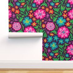 an image of a colorful wallpaper with flowers on the wall and behind it is a roll of toilet paper