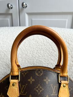 Overview Louis Vuitton Ellipse PM in monogram canvas with gold hardware. This structured bag features two top handles and is an ideal grab bag for day to day wear. Can be carried in the crook of the arm or in hand. 2006. Features Monogram coated canvas with textile lining Shiny gold hardware Smooth cowhide leather trim One main compartment 1 slip interior pocket Zip top closure Made in France Leather handles Condition Exterior: Overall very good condition with small signs of general wear. Some m Top Handle Monogram Canvas Bag With Gold-tone Hardware, Top Handle Monogram Canvas Bag With Leather Handles, Monogram Canvas Bags With Leather Handles, Classic Monogram Canvas Satchel With Gold-tone Hardware, Monogram Canvas Satchel With Detachable Double Handle, Vintage Coated Canvas Satchel With Gold-tone Hardware, Vintage Monogram Canvas Satchel With Detachable Handle, Monogram Canvas Satchel With Leather Handles For Daily Use, Daily Use Monogram Canvas Satchel With Leather Handles