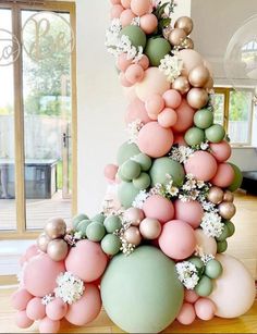 a large balloon tree is decorated with pastel colors and white flowers in the center