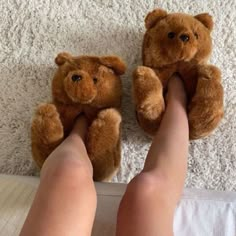 a person with their feet up on the floor next to a teddy bear