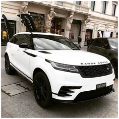 a white range rover parked in front of a building