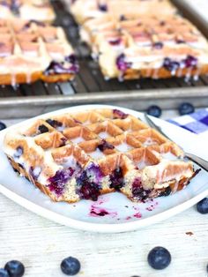 blueberry waffles are sitting on a white plate next to a cooling rack